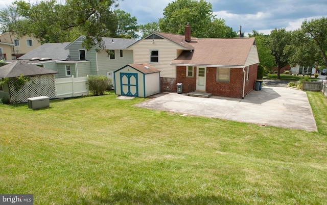 rear view of property featuring a lawn, a patio, and a storage unit