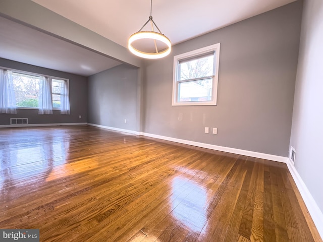 unfurnished room with plenty of natural light and dark hardwood / wood-style floors