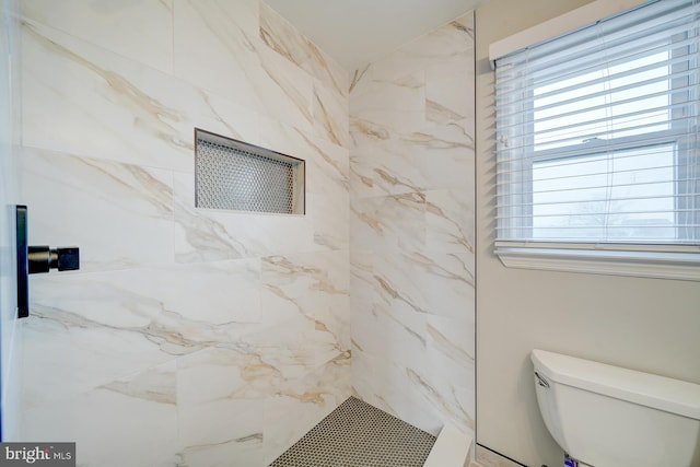 bathroom featuring toilet and tiled shower