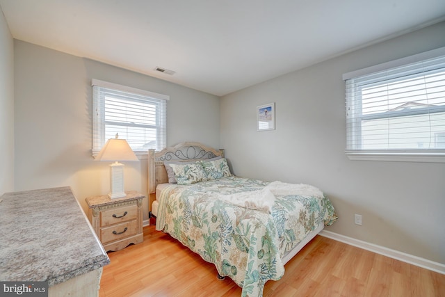 bedroom featuring light hardwood / wood-style floors and multiple windows