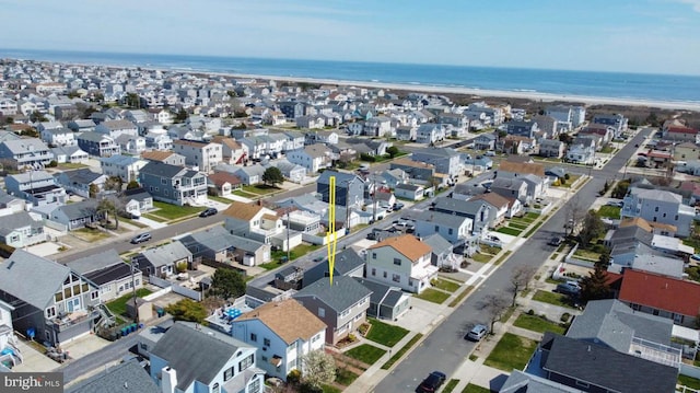 drone / aerial view featuring a water view and a view of the beach