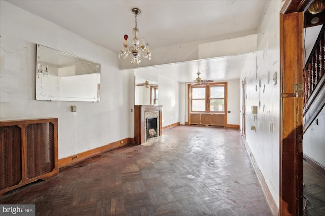 unfurnished living room featuring dark parquet flooring and ceiling fan with notable chandelier