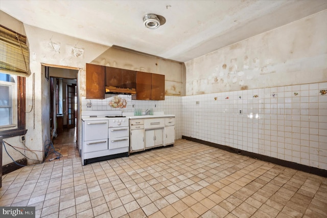 kitchen with white cabinetry and tile walls