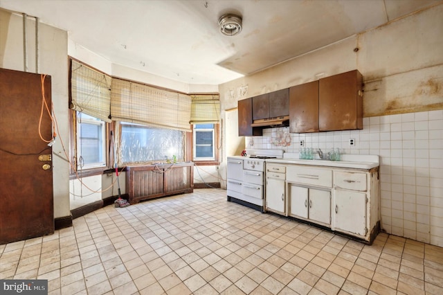 kitchen featuring tile walls and white range oven