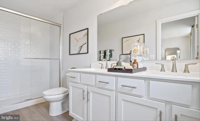 bathroom with vanity, an enclosed shower, hardwood / wood-style flooring, and toilet