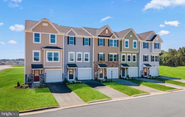 multi unit property with a front yard and a garage