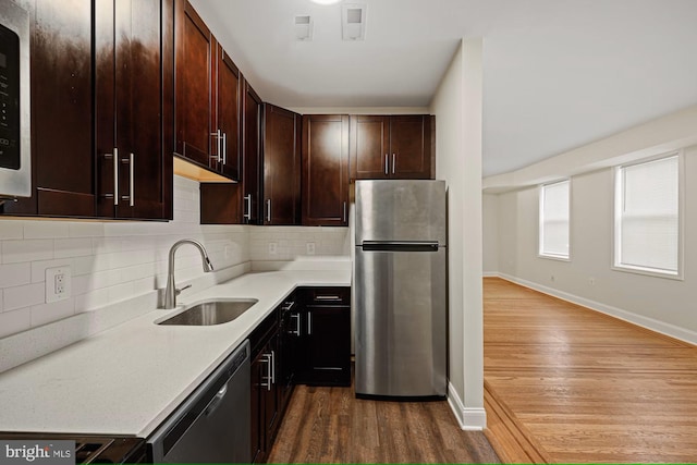 kitchen with backsplash, sink, dark wood-type flooring, and appliances with stainless steel finishes