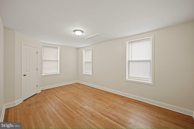 empty room with plenty of natural light and light hardwood / wood-style floors