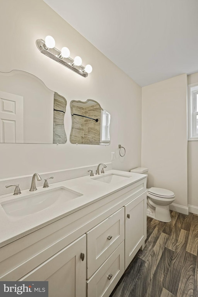 bathroom featuring wood-type flooring, vanity, and toilet