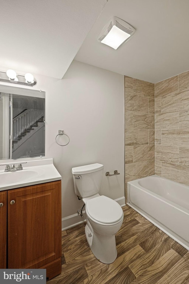 full bathroom with hardwood / wood-style flooring, vanity, toilet, and tiled shower / bath