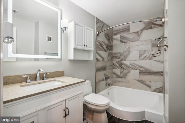 full bathroom featuring toilet, tiled shower / bath, and vanity