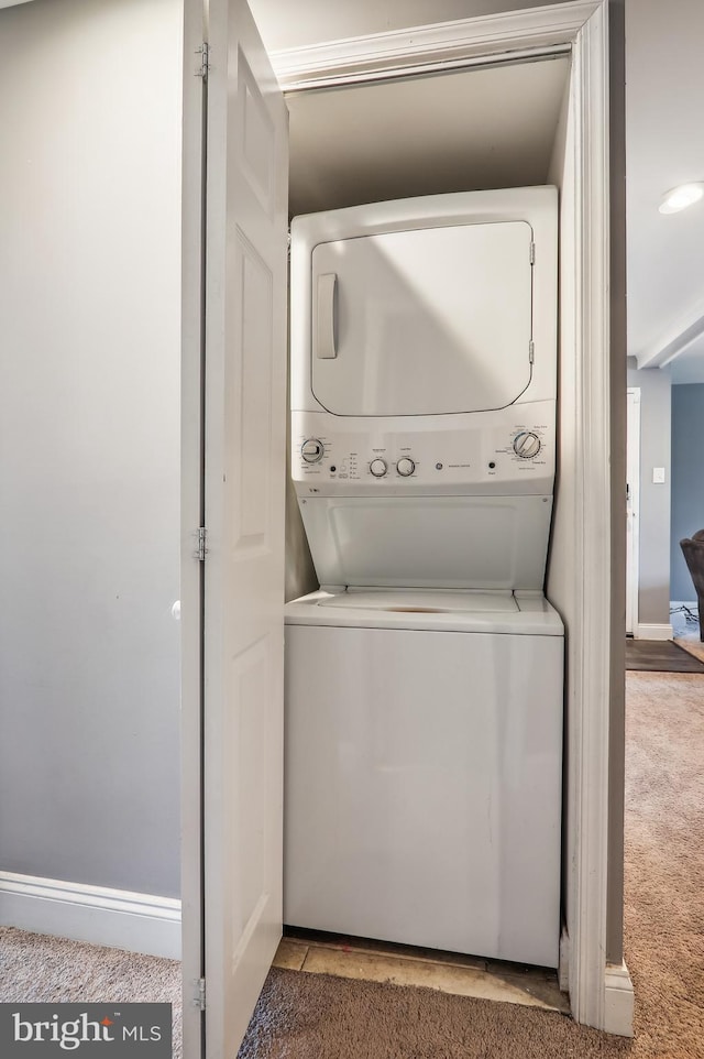 laundry area featuring carpet flooring and stacked washer and dryer