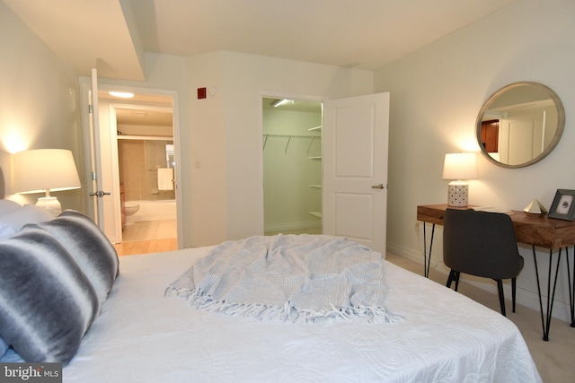 tiled bedroom with ensuite bathroom, a walk in closet, and a closet