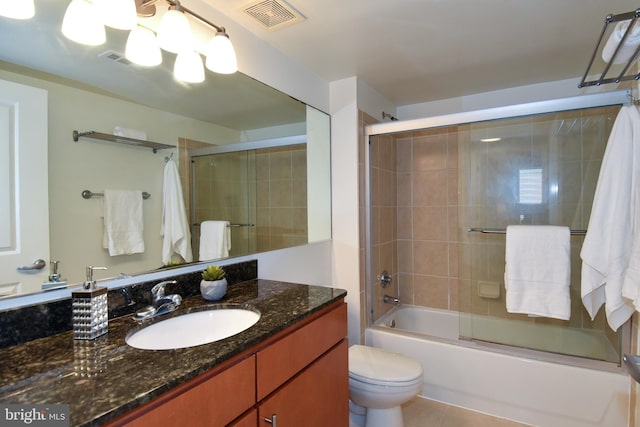 full bathroom with vanity, toilet, tile patterned flooring, and bath / shower combo with glass door