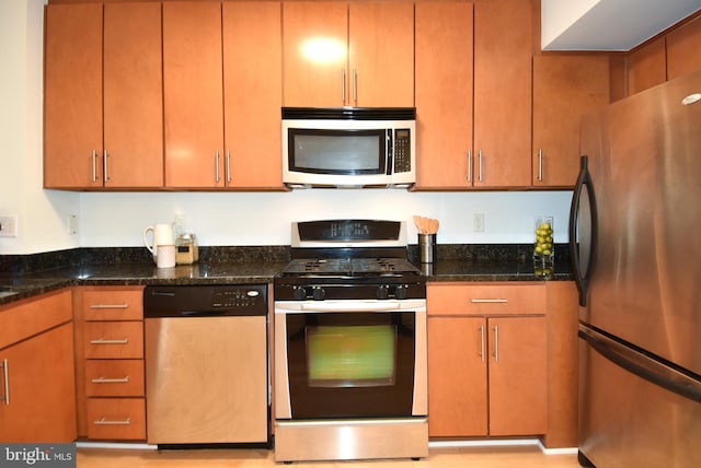 kitchen featuring appliances with stainless steel finishes and dark stone counters