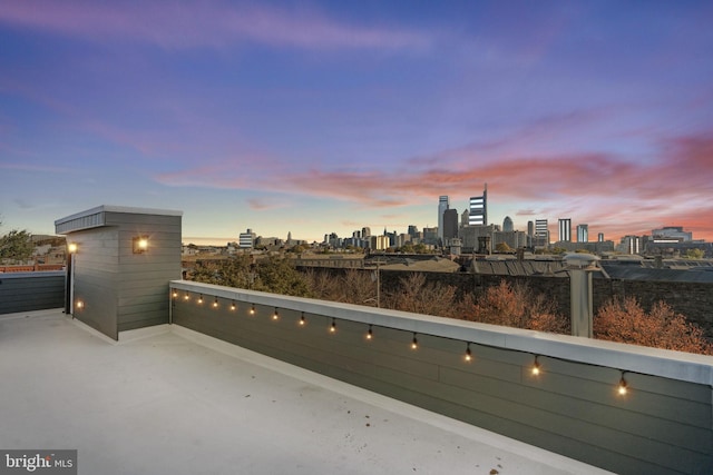 patio terrace at dusk featuring a balcony