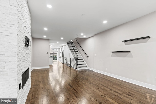 unfurnished living room featuring a fireplace and dark hardwood / wood-style floors