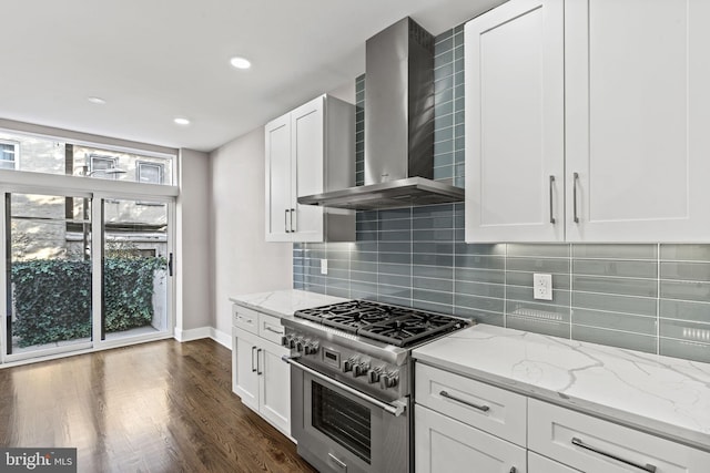 kitchen featuring white cabinetry, a healthy amount of sunlight, wall chimney exhaust hood, and stainless steel stove