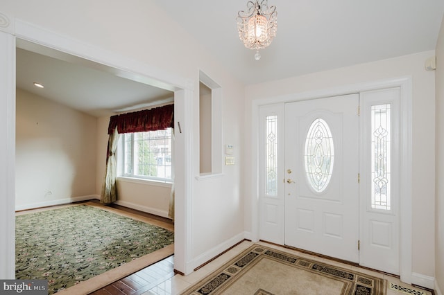 foyer entrance with hardwood / wood-style flooring and an inviting chandelier