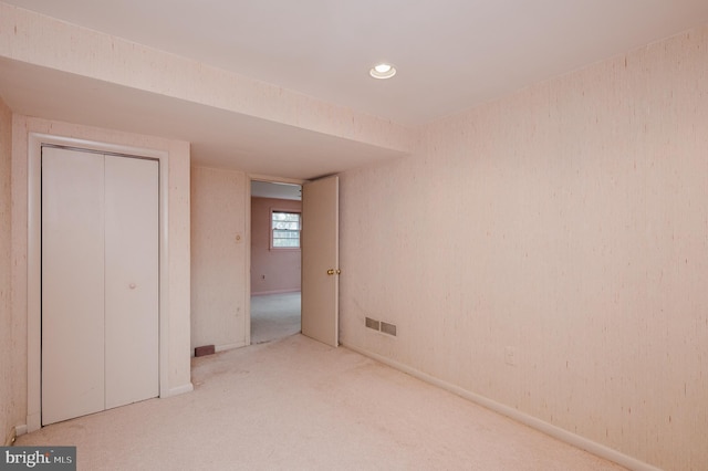 unfurnished bedroom featuring a closet and light colored carpet