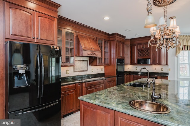 kitchen featuring premium range hood, dark stone counters, sink, black appliances, and a chandelier