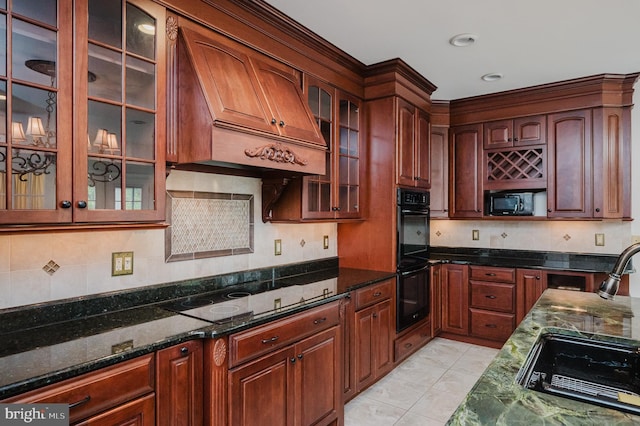 kitchen with custom exhaust hood, backsplash, dark stone counters, black appliances, and sink