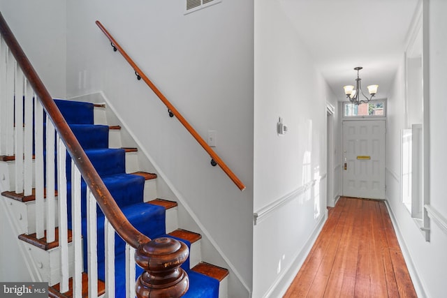 foyer with hardwood / wood-style floors and a chandelier