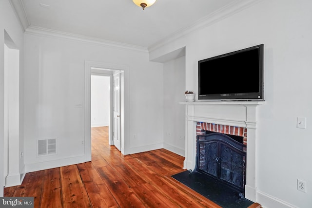 unfurnished living room featuring a brick fireplace, crown molding, and wood-type flooring