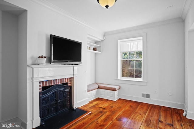 unfurnished living room featuring crown molding, wood-type flooring, and a fireplace