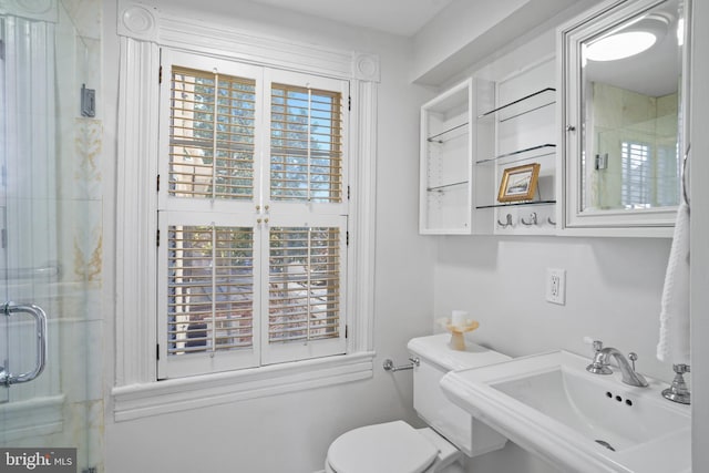 bathroom featuring sink, an enclosed shower, and toilet