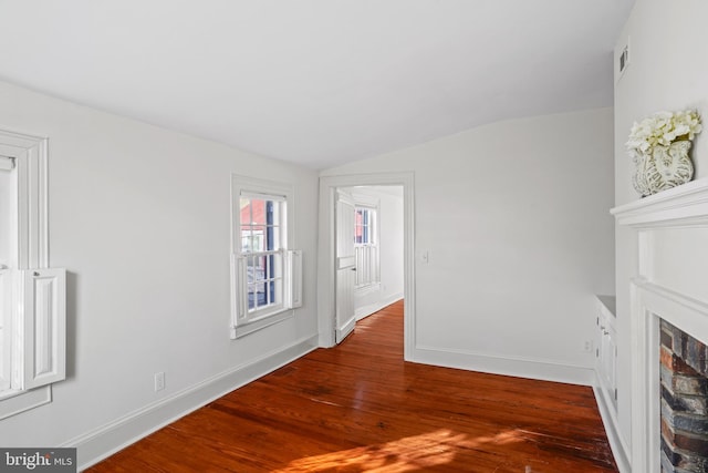 unfurnished living room featuring hardwood / wood-style flooring and vaulted ceiling