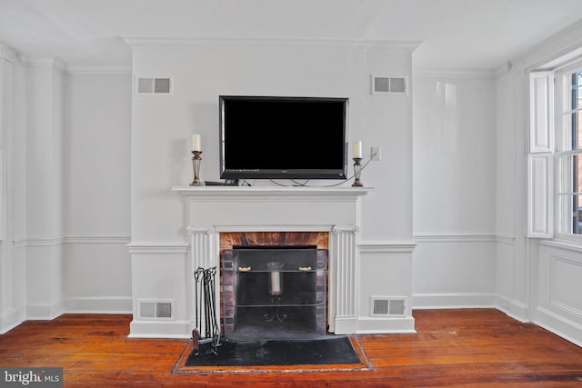 unfurnished living room with dark hardwood / wood-style flooring, a brick fireplace, and ornamental molding