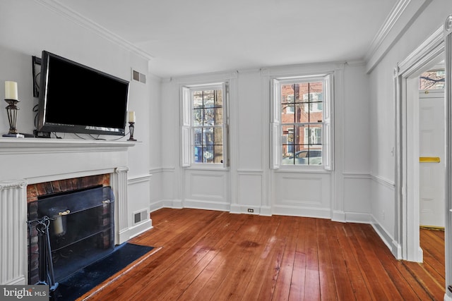 unfurnished living room with wood-type flooring and crown molding