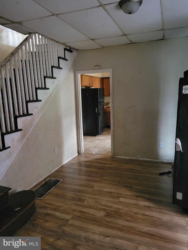 corridor featuring a drop ceiling and wood-type flooring