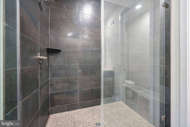 bathroom featuring toilet and an enclosed shower