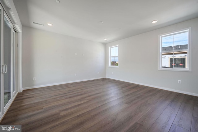 empty room with dark hardwood / wood-style flooring