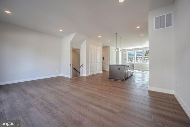 unfurnished living room with sink and dark hardwood / wood-style flooring