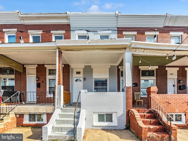 443 Robinson St N, Baltimore, MD 21224 - townhome / multi-family property with brick siding, a porch, and stairway