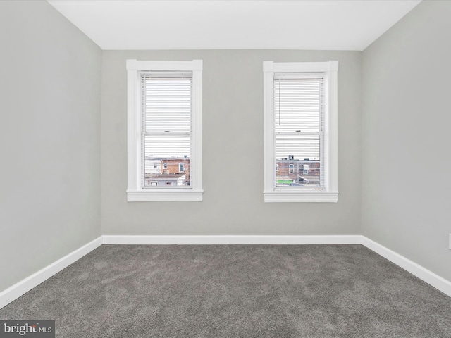 unfurnished room featuring dark carpet