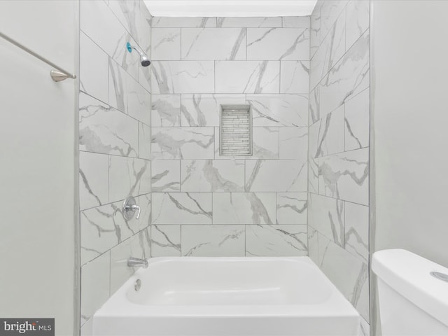 bathroom with tiled shower / bath and toilet