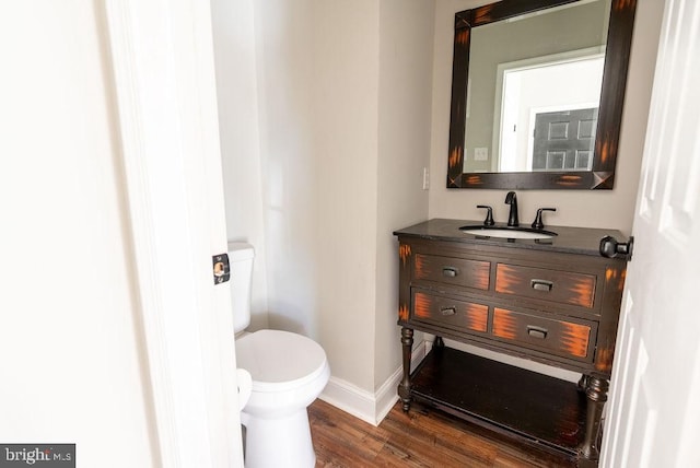 bathroom with hardwood / wood-style floors, vanity, and toilet