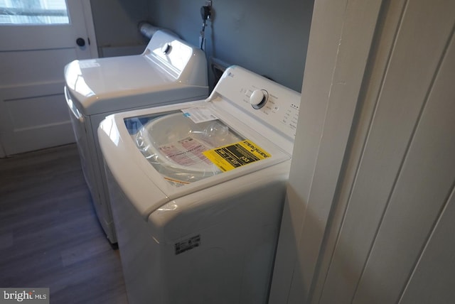 laundry room with separate washer and dryer and dark wood-type flooring