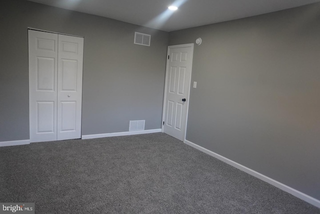 unfurnished bedroom featuring carpet and a closet