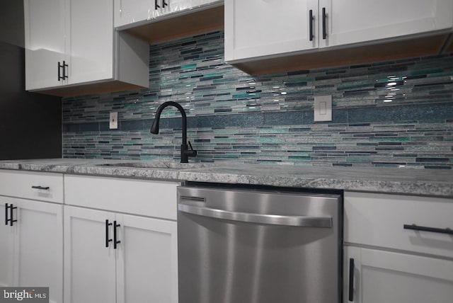 kitchen with white cabinetry, dishwasher, sink, tasteful backsplash, and light stone counters