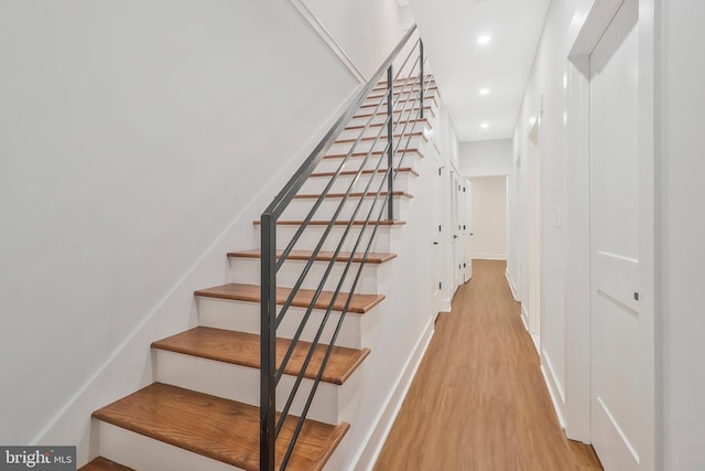 staircase with hardwood / wood-style floors