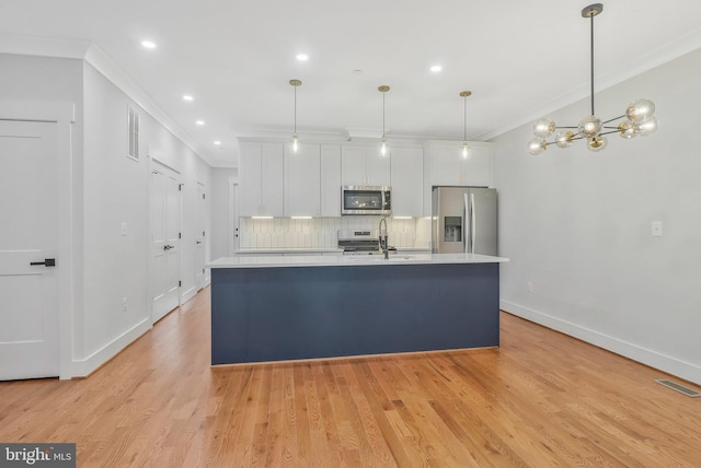 kitchen featuring a kitchen island with sink, white cabinetry, light hardwood / wood-style flooring, and stainless steel appliances