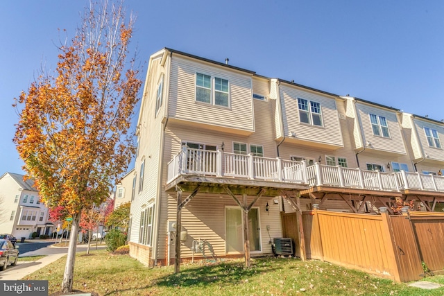 back of property with a deck, a lawn, and cooling unit