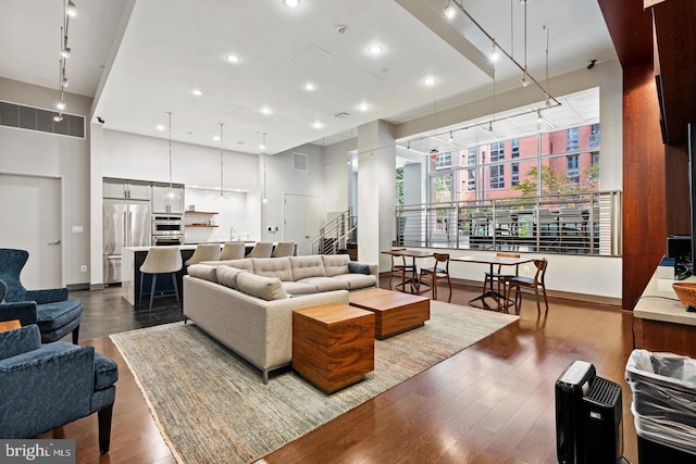 living room with a high ceiling and hardwood / wood-style flooring