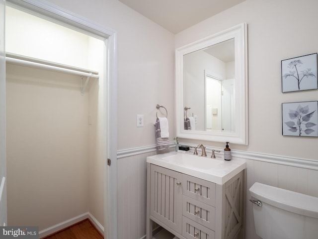 bathroom with vanity, toilet, and hardwood / wood-style floors