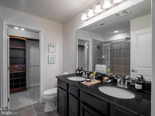 bathroom with vanity, tile patterned floors, toilet, and an enclosed shower